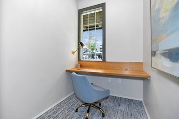 a desk with a chair in a room with a window